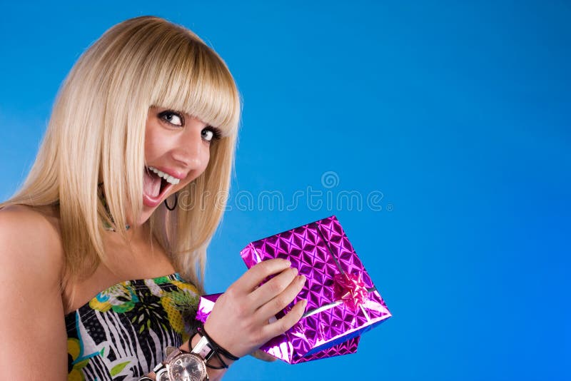 Happy girl with gift box over blue