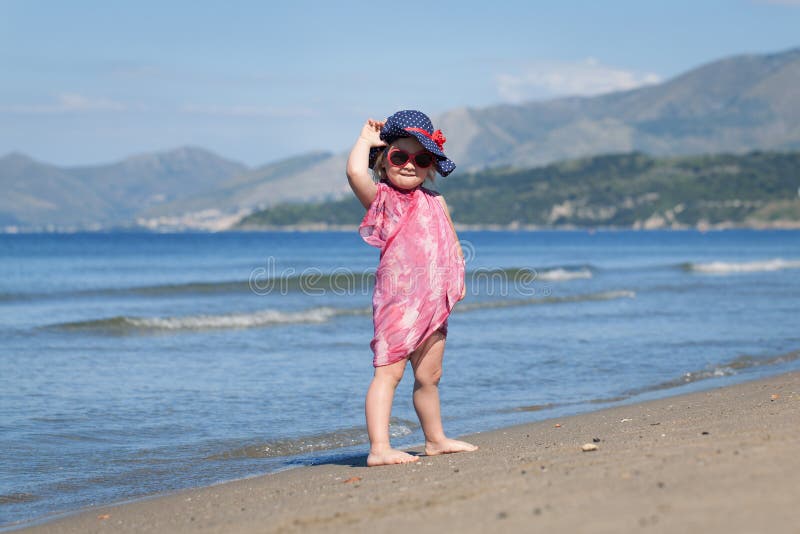 Happy girl in hat and sunglasses, walking near sea stock images Happy girl in hat and sunglasses, walking near sea stock images
