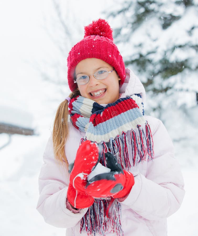 Happy girl having fun on snowing winter day. stock photo