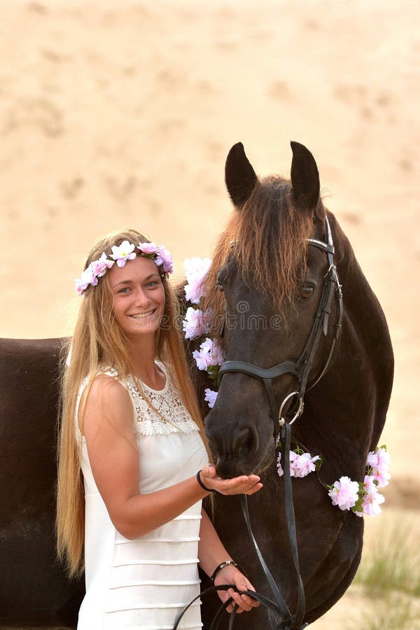 Happy girl and her black Frisian horse