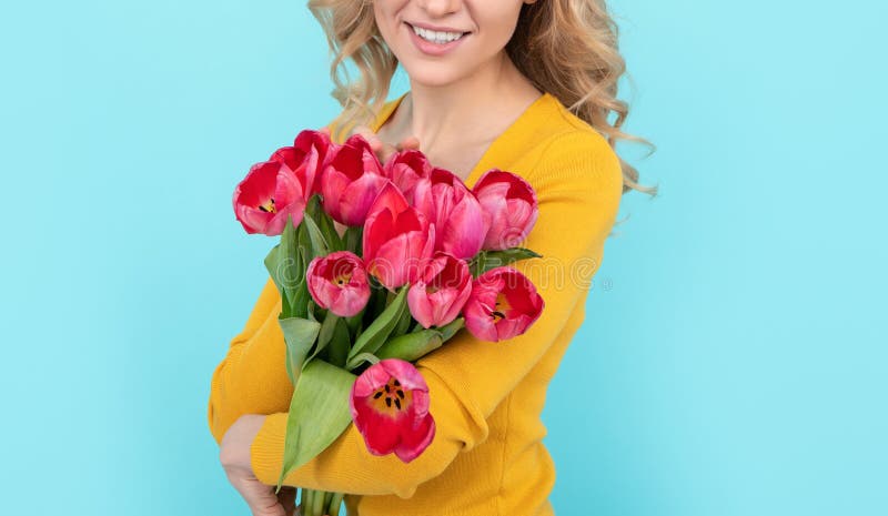 happy girl hold spring tulip flowers on blue background stock image