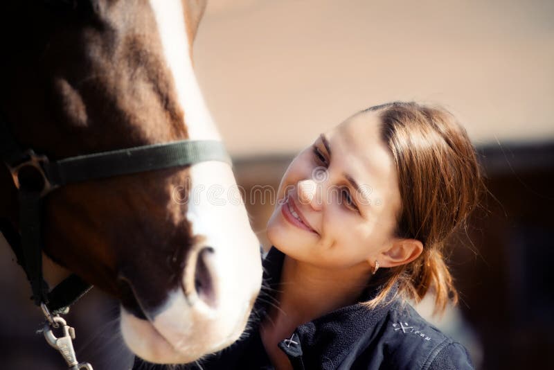 Ritratto sorridente giovane donna con cavallo.