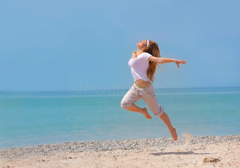 Happy girl jumping on beach