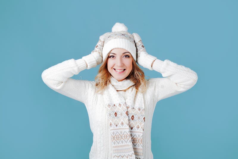 Happy girl laughing and playing with snow. Woolen knitted clothes