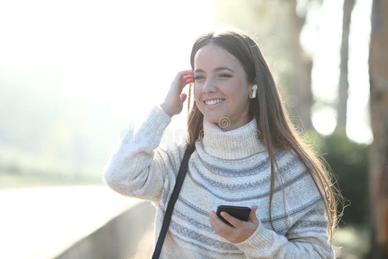 Happy girl listens to music looking away in a park stock photography Happy girl listens to music looking away in a park stock photography