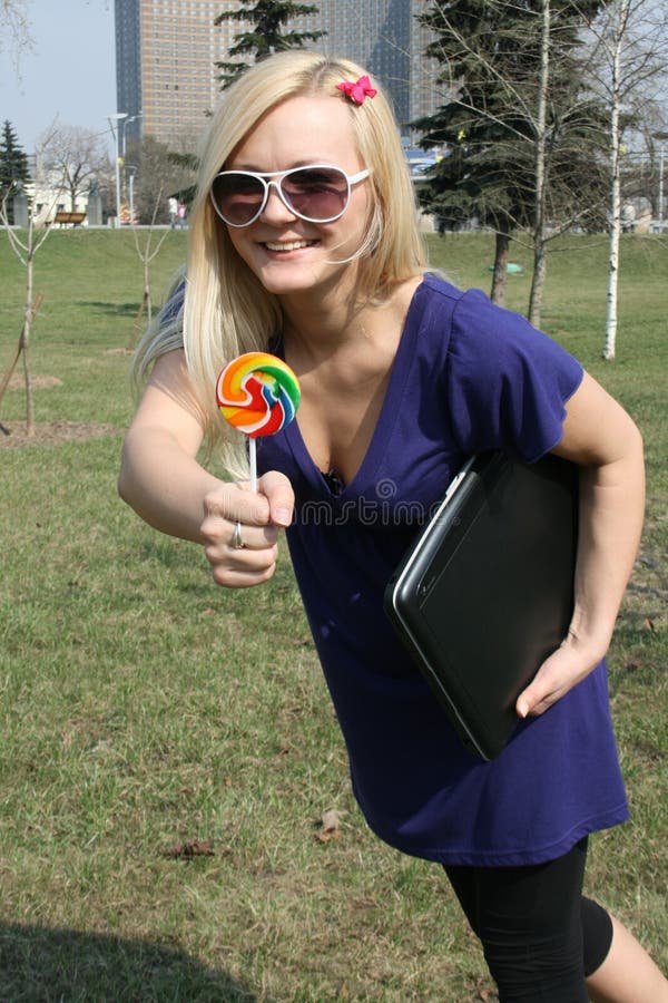 Happy girl with lollipop and laptop