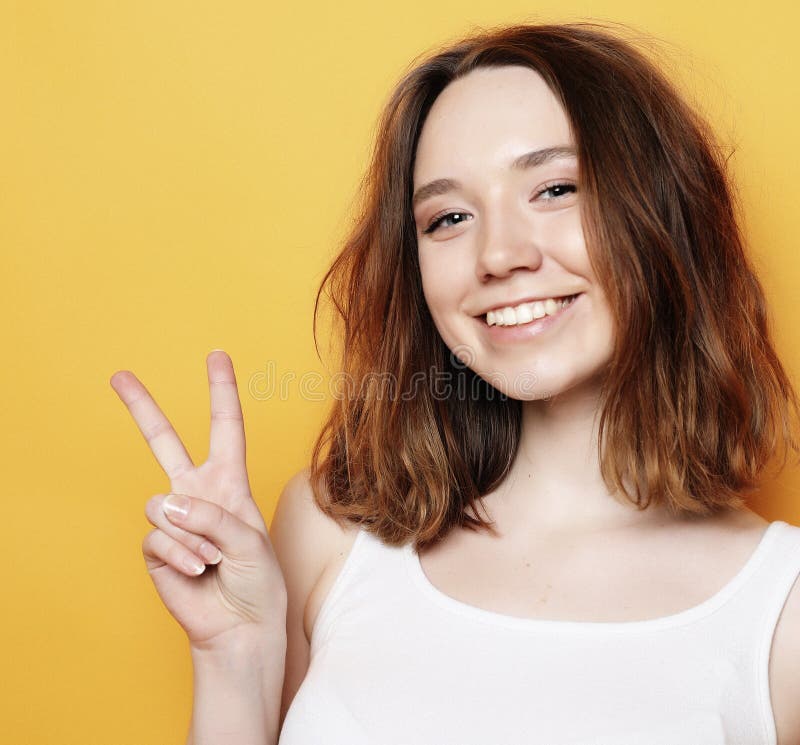 Happy Girl Looking At Camera With Smile And Showing Peace Sign With 