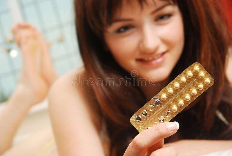 Happy girl looking at her contraceptive pills