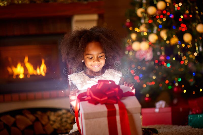 Happy girl looking in open magic Christmas present
