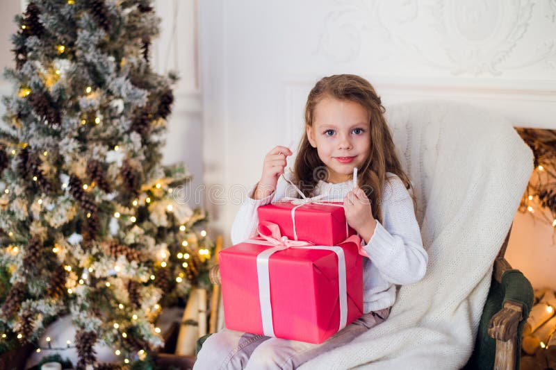 Happy Girl Opening Christmas Gifts by a Decorated Fireplace in Cozy ...
