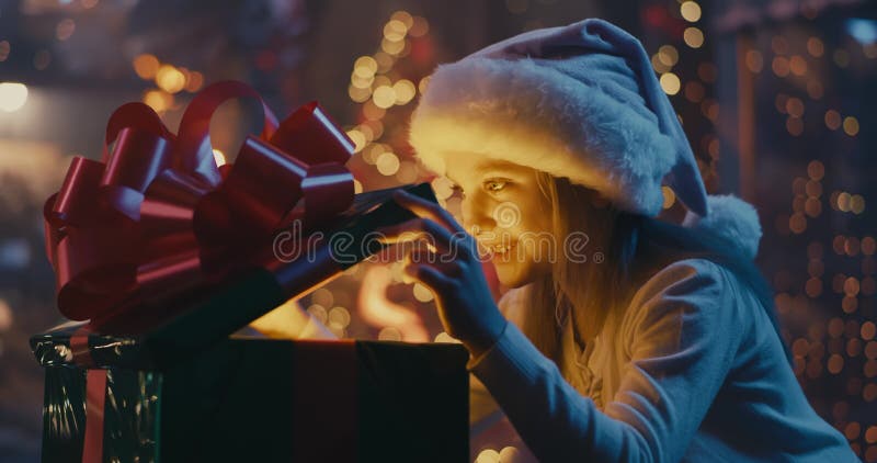 Happy girl opening magic Christmas present