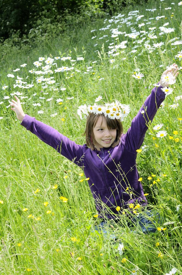 Happy girl playing in field with flowers