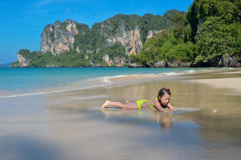 Happy girl plays in sea on tropical beach