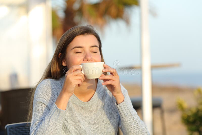 Happy girl relaxing smelling coffee aroma in a cafe royalty free stock photos Happy girl relaxing smelling coffee aroma in a cafe royalty free stock photos