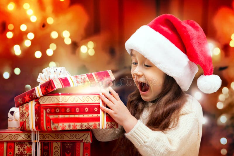 Happy Girl in Santa Hat Opening a Gift Box