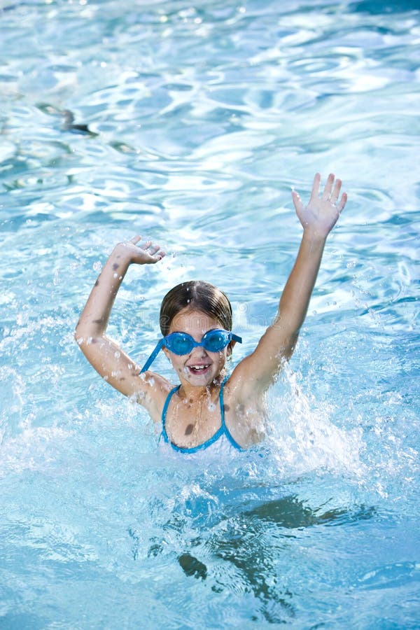 Happy girl splashing in swimming pool