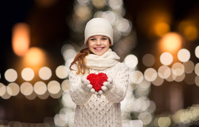 Happy girl in winter clothes with red heart