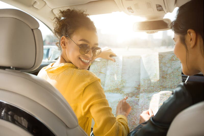 Happy Girls Friends Looking At Road Map Sitting In Automobile stock images Happy Girls Friends Looking At Road Map Sitting In Automobile stock images