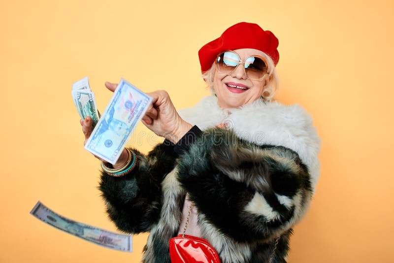 Happy glamour senior old lady throwing stack of dollar bills stock photo Happy glamour senior old lady throwing stack of dollar bills stock photo