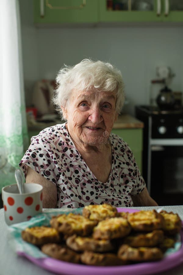Happy Grandma is Sitting in the Kitchen with Pastries Stock Photo ...