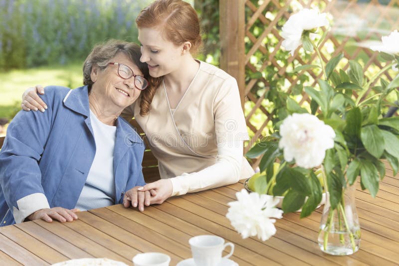 Happy grandmother enjoying time with friendly nurse on the terra royalty free stock image Happy grandmother enjoying time with friendly nurse on the terra royalty free stock image