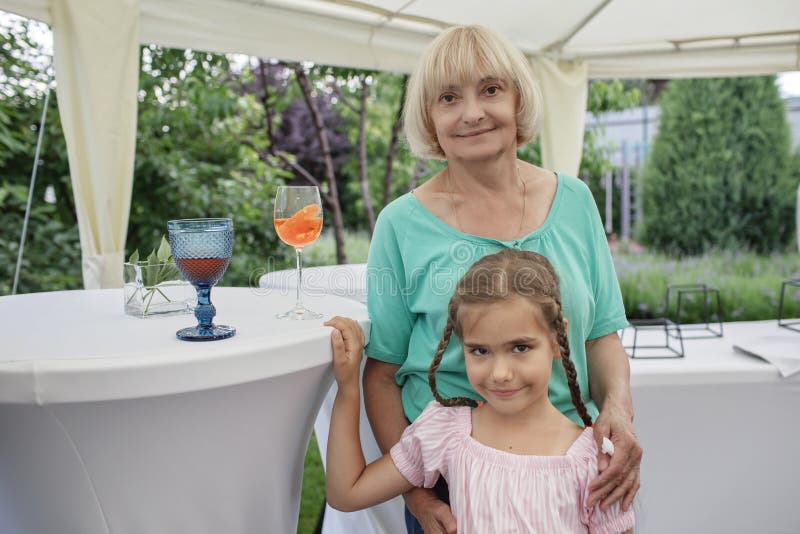 Happy grandmother with her grandchild during backyard retirement party at summer, happy seniors