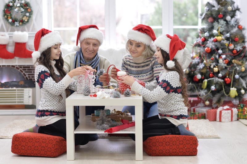 Happy grandparents with twin girls preparing for Christmas at home royalty free stock photo Happy grandparents with twin girls preparing for Christmas at home royalty free stock photo