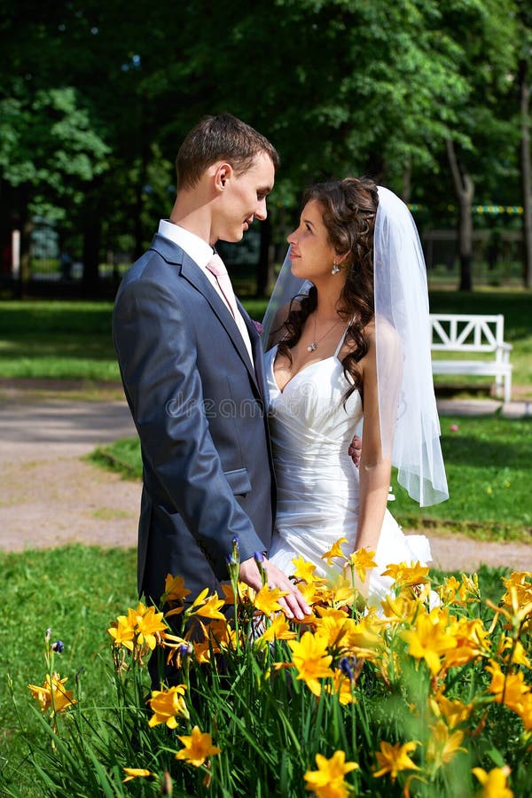 Happy groom and happy bride near yellow flowers