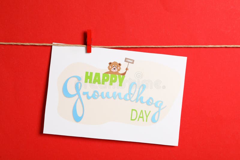 Happy Groundhog Day greeting card hanging on red background