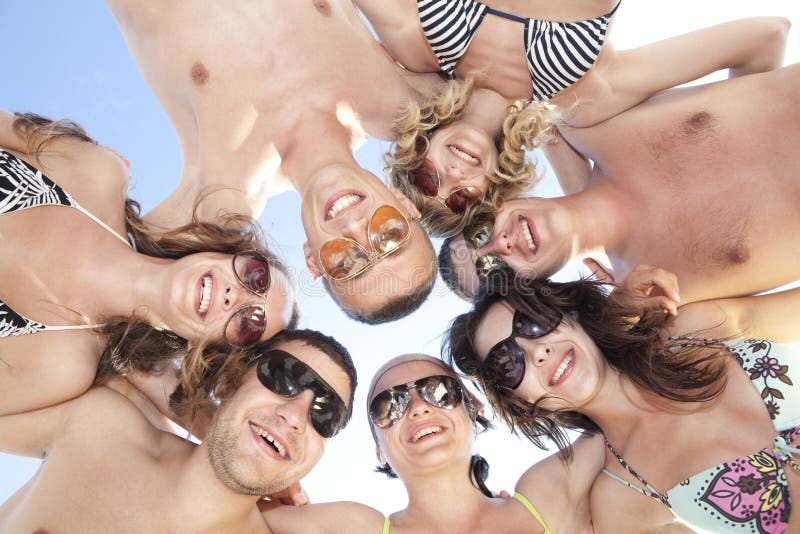 Happy guys and girls standing together in a circle