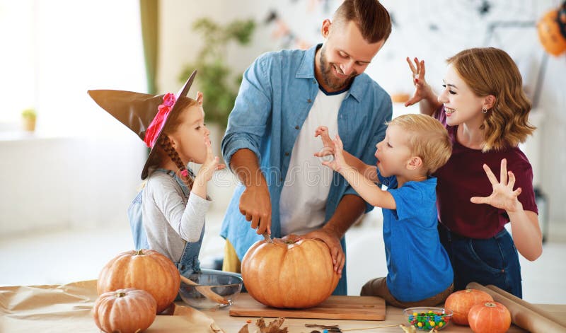 Happy Halloween! family mother father and children cut pumpkin for holiday at home stock photos Happy Halloween! family mother father and children cut pumpkin for holiday at home stock photos