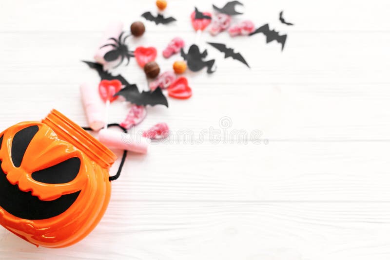 Happy Halloween. Halloween candy spilled from jack o lantern bucket with skulls, black bats, ghost, spider decorations on white royalty free stock photos Happy Halloween. Halloween candy spilled from jack o lantern bucket with skulls, black bats, ghost, spider decorations on white royalty free stock photos