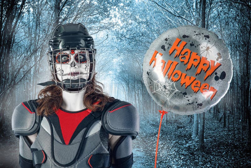 Happy halloween. hockey player in a hockey helmet and mask with a balloon against the backdrop or background of scary forest. All royalty free stock photography Happy halloween. hockey player in a hockey helmet and mask with a balloon against the backdrop or background of scary forest. All royalty free stock photography