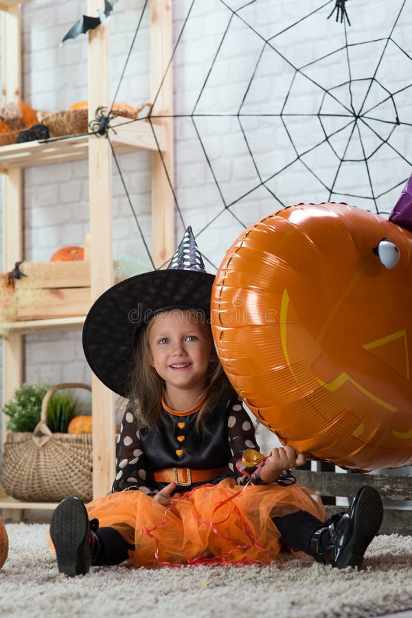 Happy Halloween. A little beautiful girl in a witch costume celebrates a home in an interior royalty free stock images Happy Halloween. A little beautiful girl in a witch costume celebrates a home in an interior royalty free stock images