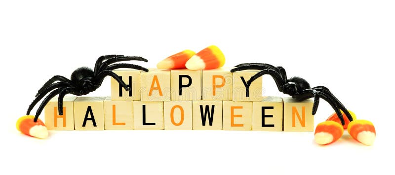 Happy Halloween wooden blocks with toy spider and candy corn isolated on a white background. Happy Halloween wooden blocks with toy spider and candy corn isolated on a white background