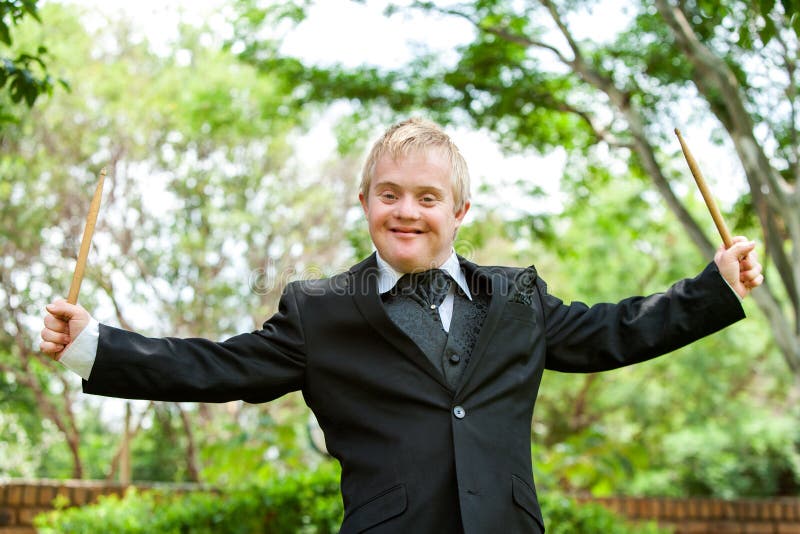 Portrait of young handicapped drummer with arms open outdoors. Portrait of young handicapped drummer with arms open outdoors.