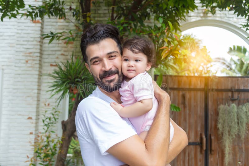 Happy handsome father holding adorable little baby daughter at house with happiness and smile face. Single dad embrace his infant