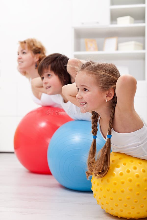 Happy healthy kids exercising together with their mother