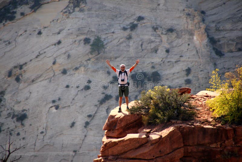 Happy hiker celebrates position at rock edge.