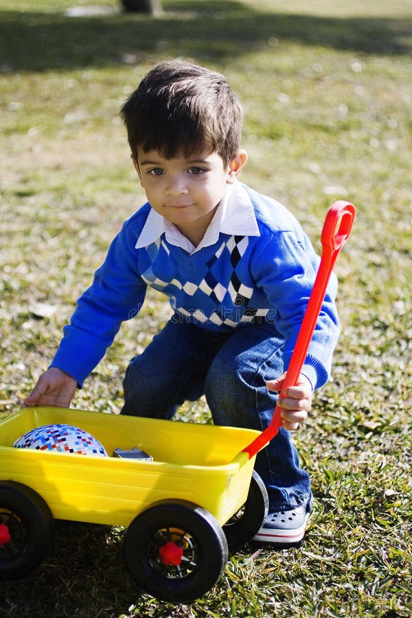 Happy hispanic boy playing with his toy truck