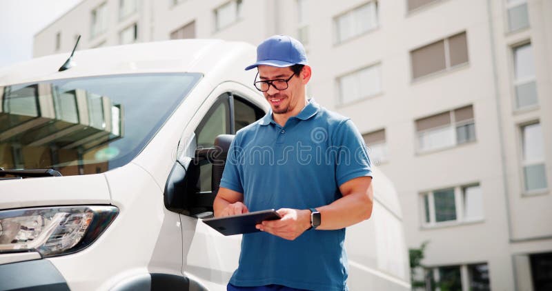 Happy Hispanic Courier Using Tablet To Deliver Packages royalty free stock image
