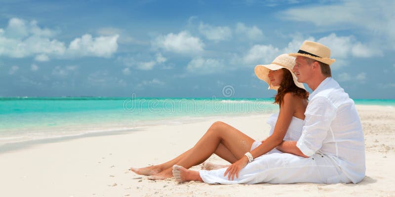 Happy honeymoon vacation at summer. Couple relax on the white sand of beach. Happy sea lifestyle. Young family, man and woman rest stock image Happy honeymoon vacation at summer. Couple relax on the white sand of beach. Happy sea lifestyle. Young family, man and woman rest stock image