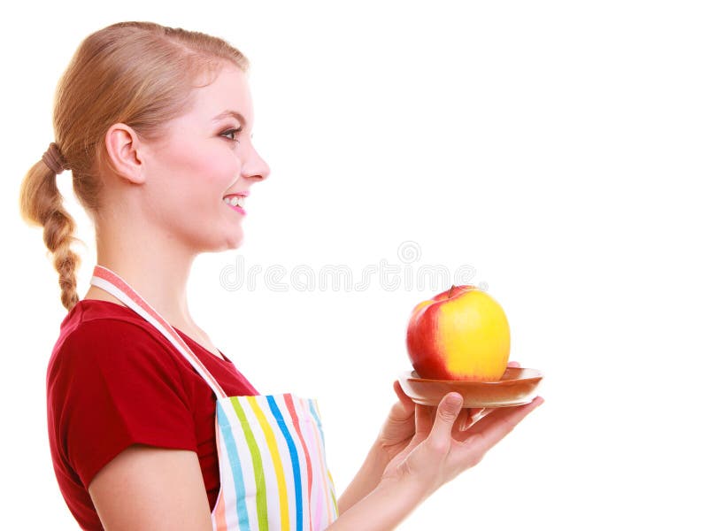 Happy housewife or chef in kitchen apron offering apple isolated royalty free stock photography Happy housewife or chef in kitchen apron offering apple isolated royalty free stock photography