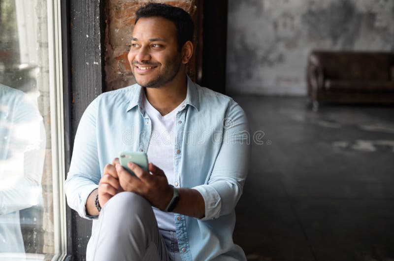 Happy Indian Dark-haired Man in Casual Shirt Using Smartphone in Loft Style  Apartment Stock Photo - Image of smart, wear: 226818606