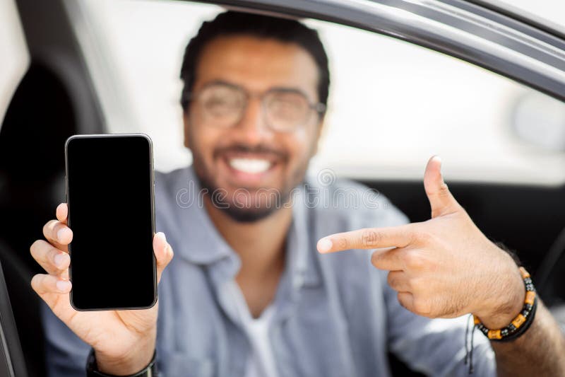Happy indian man driver holding smartphone with empty screen, mockup stock photography