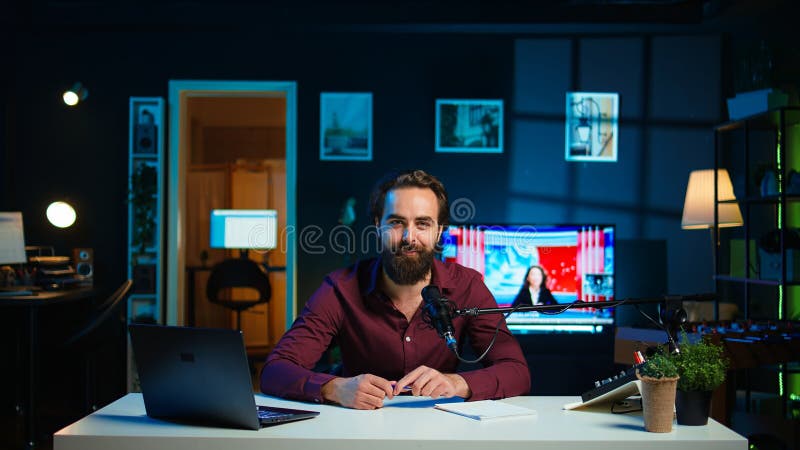 Happy influencer przy użyciu mikrofonu docierającego do ciemno oświetlonego domu studio wnętrze fotografia stock