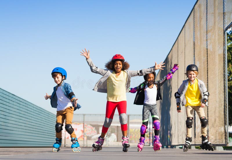 Happy inline skaters, preteen boys and girls, having fun at stadium outdoors. Happy inline skaters, preteen boys and girls, having fun at stadium outdoors