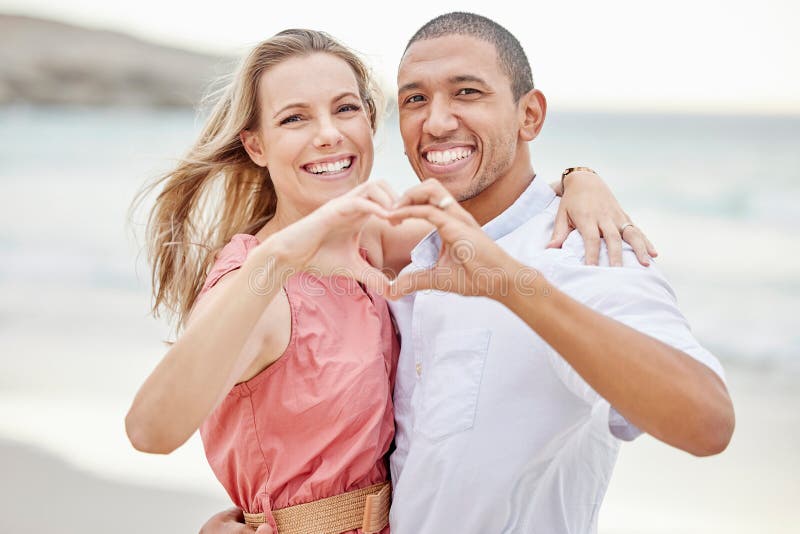 Happy Interracial Couple Show Heart Sign With Their Hands And Enjoying Fresh Air On Vacation At