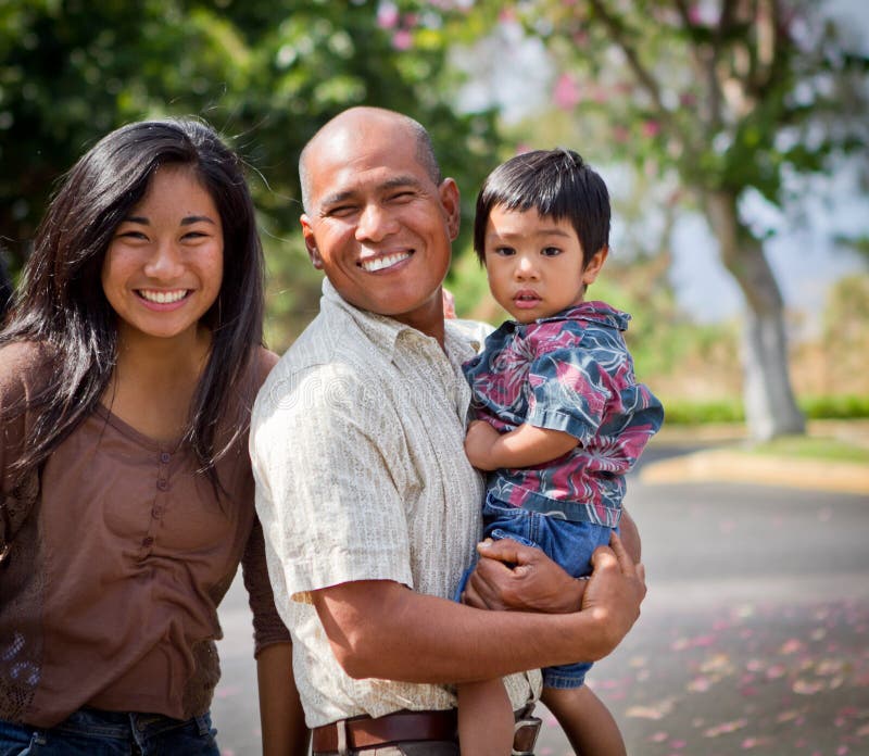 This happy island family, father, daughter and son, are captured in this tropical, park like setting in Hawaii.