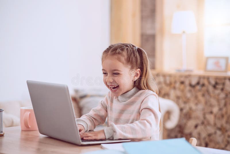 Happy joyful girl playing on a laptop stock photos Happy joyful girl playing on a laptop stock photos
